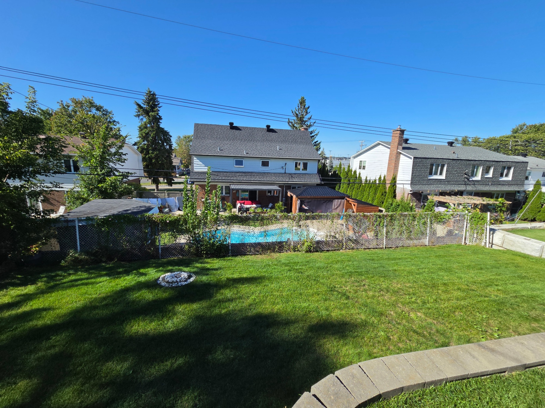 Pelouse arrière fraîchement entretenue avec piscine dans l'Ouest-de-l'Île